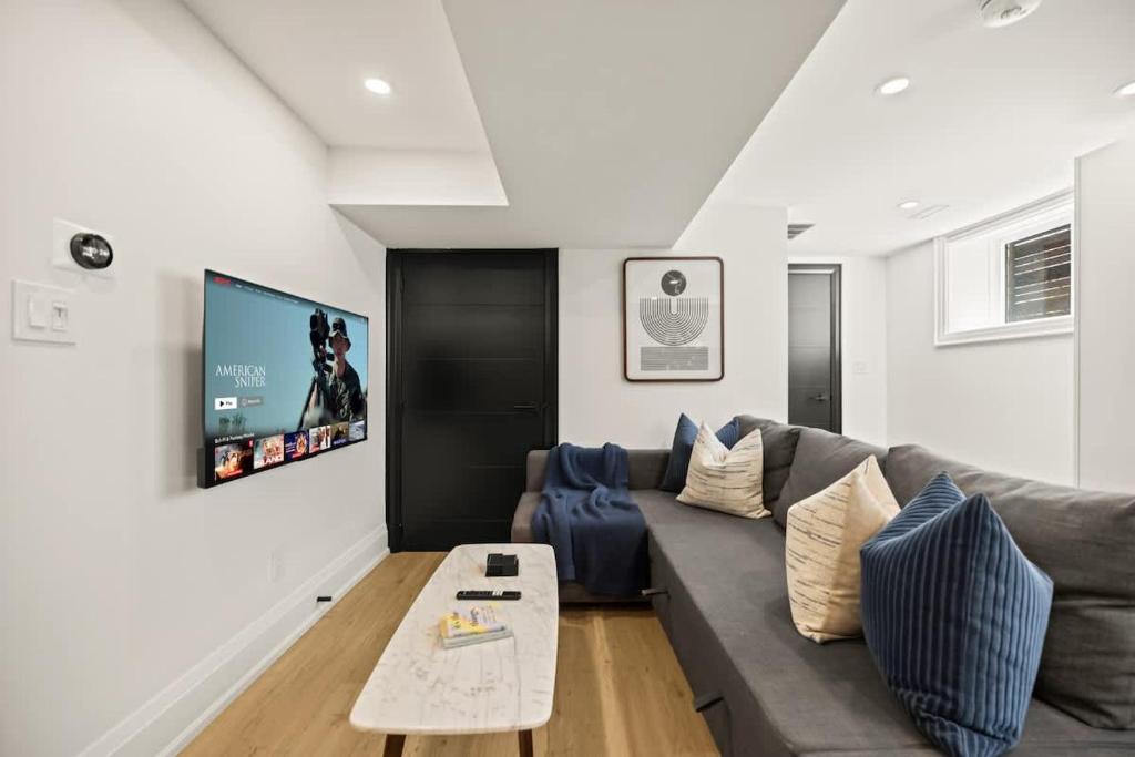 un soggiorno con divano e TV a schermo piatto di Bright 1Bedroom Escape in Torontos West End a Toronto