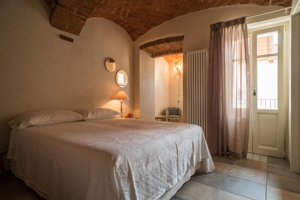 Un dormitorio con una cama y una ventana grande. en Acini Sparsi, en Montalenghe