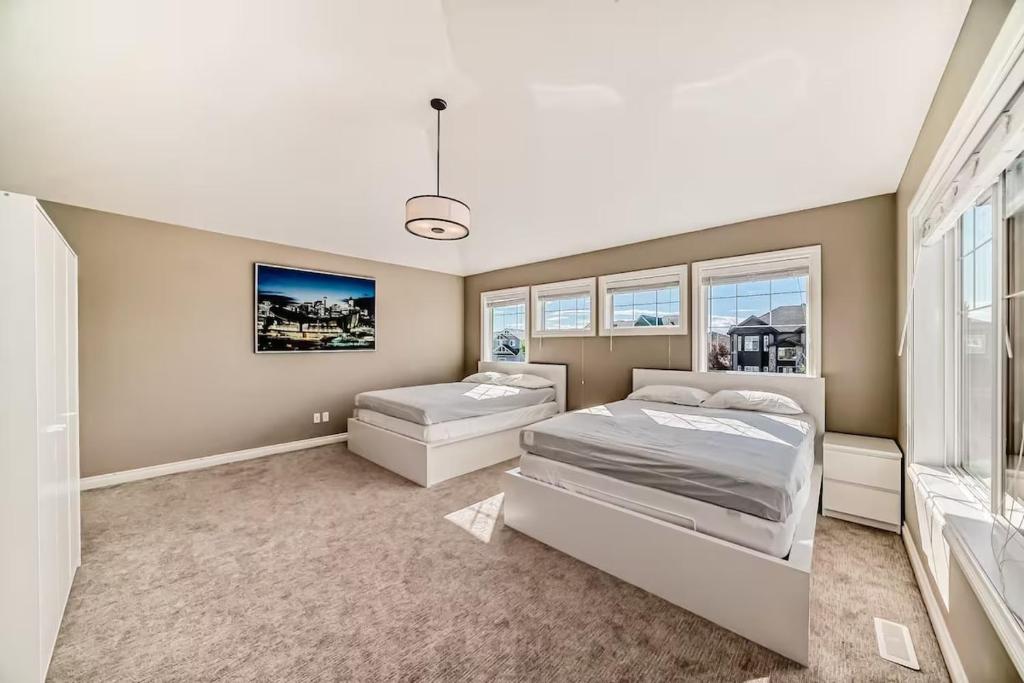 艾尔德里Waterfront Home, Fireplace, 90 min to Banff的一间有两张床和一扇大窗户的卧室