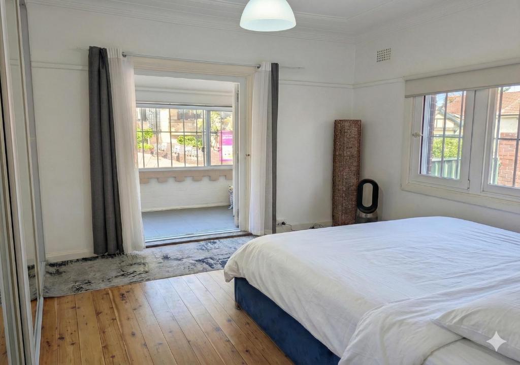 Un dormitorio con una cama grande y una ventana. en Home in Leichhardt, Sydney, en Sídney