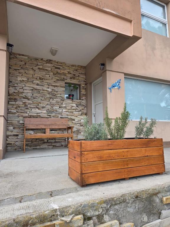 a wooden planter and a bench in front of a building at Miro del Mar in Puerto Pirámides