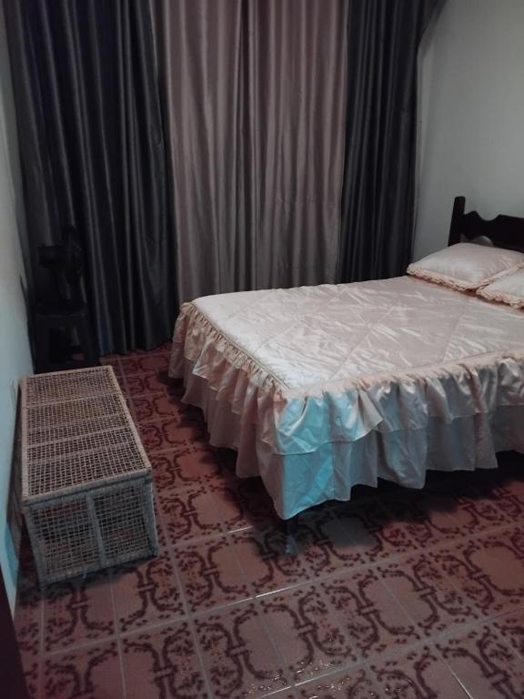 une chambre avec un lit et un tapis dans l'établissement Edifício solar de Piuma, à Piúma