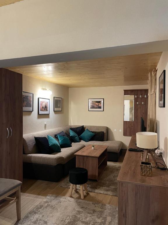 ein Wohnzimmer mit Sofa und Tisch in der Unterkunft Planinska kuca ANDJELA 2 in Mitrovac