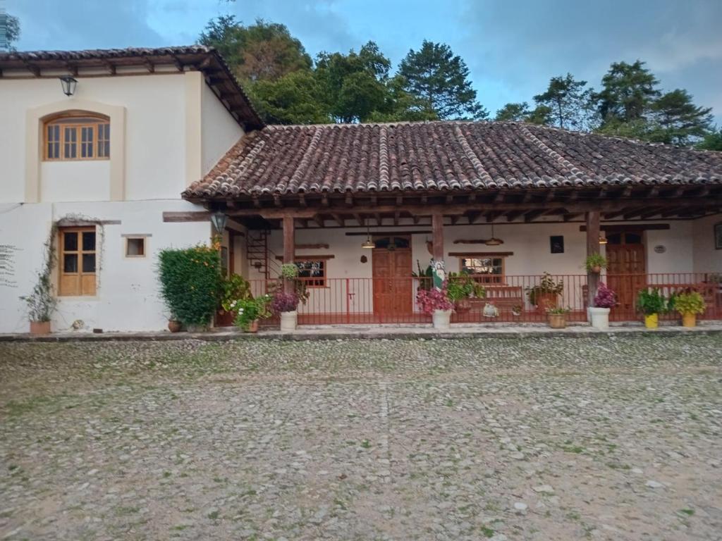 CedroHacienda San Isidro, Corral de Piedra的一栋白色房子，屋顶是棕色的。