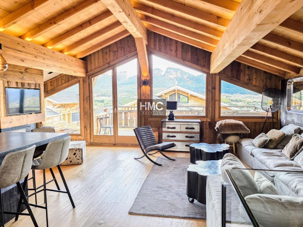 ein Wohnzimmer mit Holzdecken und einem großen Fenster in der Unterkunft Chalet K Jacuzzi et vue in Bolquere