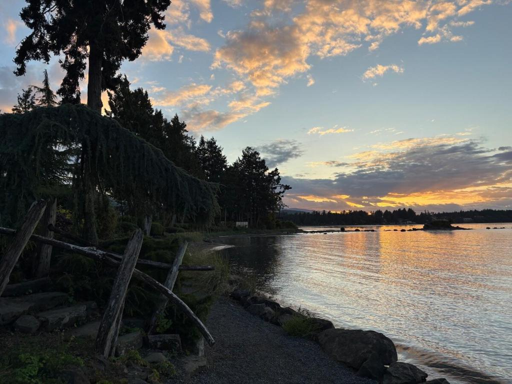 那诺斯湾Oceanside GetAway at Pacific Shores的落日,在水体上,有栅栏