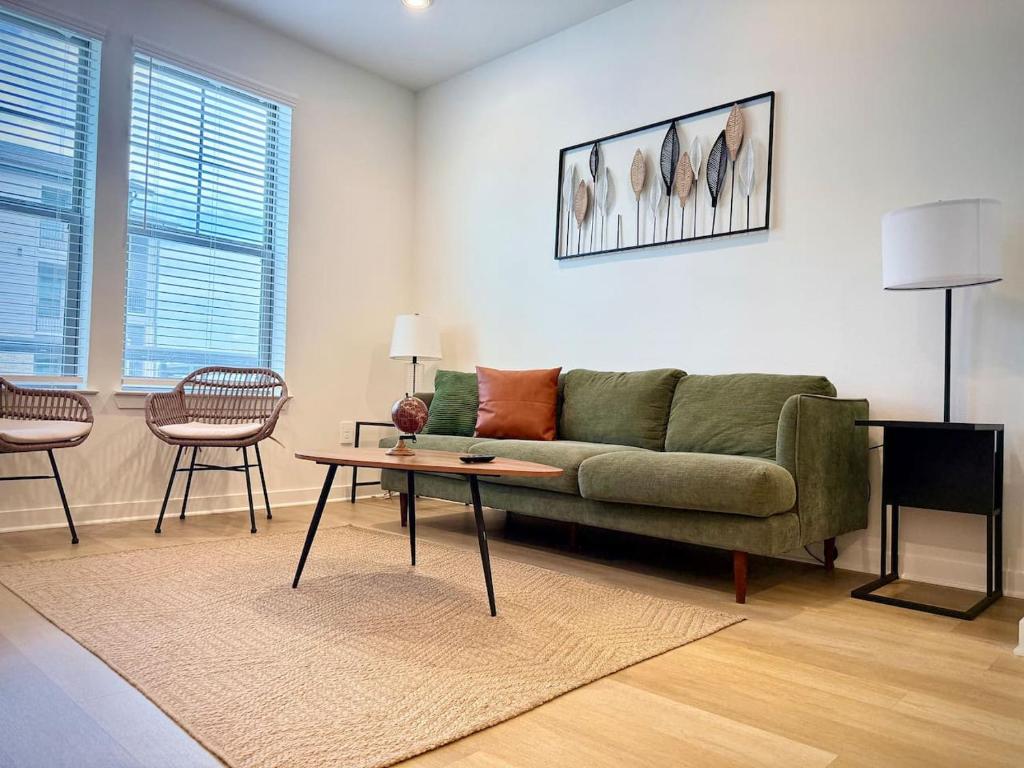 Una sala de estar con un sofá verde y una mesa. en WorkerFriendly Gym Pool WasherDryer A plus Location, en Sherman