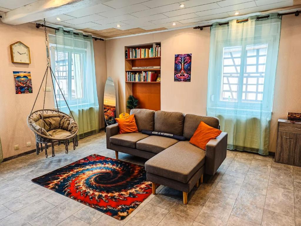 a living room with a couch and a swing at Appartement charmant et atypique, wifi, terrasse, jardin in Schleithal