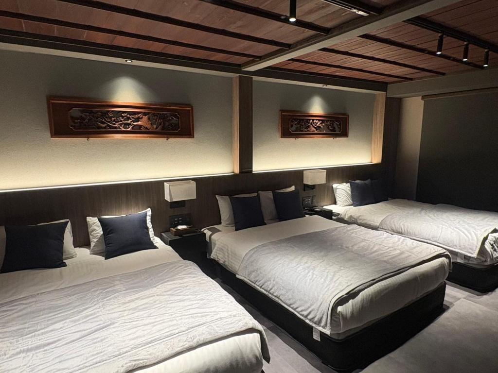 una stanza con tre letti in una stanza di SORAIRO Miyajima a Hatsukaichi