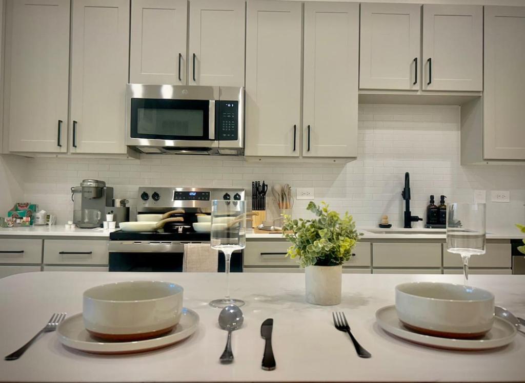 a kitchen with white cabinets and two bowls on a counter at WorkerFriendly KINGbed A plus Location Washer Wifi Pool in Sherman