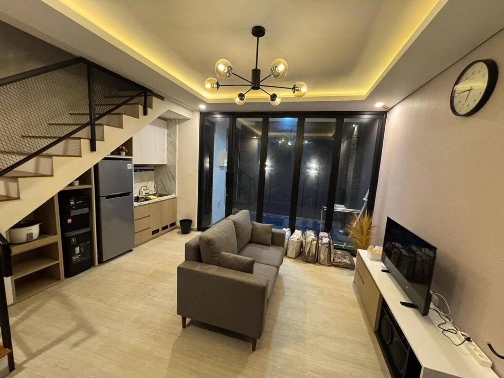 ein Wohnzimmer mit einer Couch und einer Treppe in der Unterkunft NZ Villa Guesthouse Aesthetic Batu in Malang