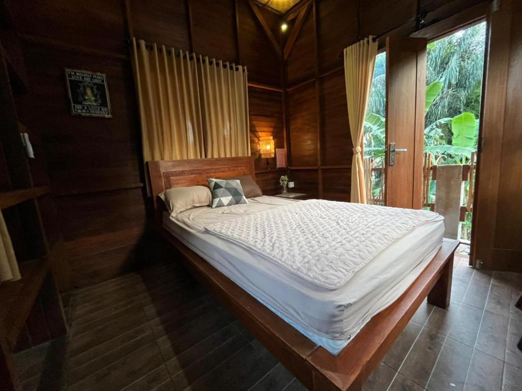 a large bed in a room with a window at Kubu Nadhi in Ketewel