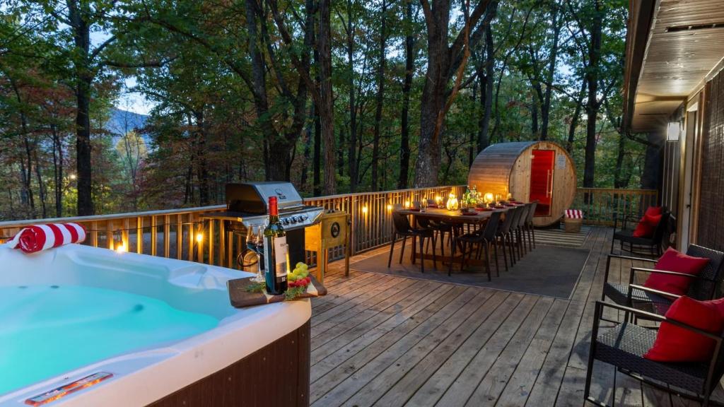 une terrasse avec un bain à remous, une table et des chaises dans l'établissement Lodge-Style Home Near Gatlinburg w Theater Hot Tub Game Room Evergreen Escape by AvantStay, à Pittman Center