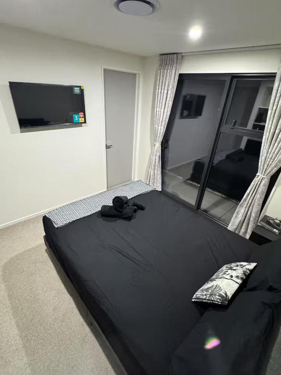 a bedroom with a black bed with a mirror at Cedarstone Villa in Halswell