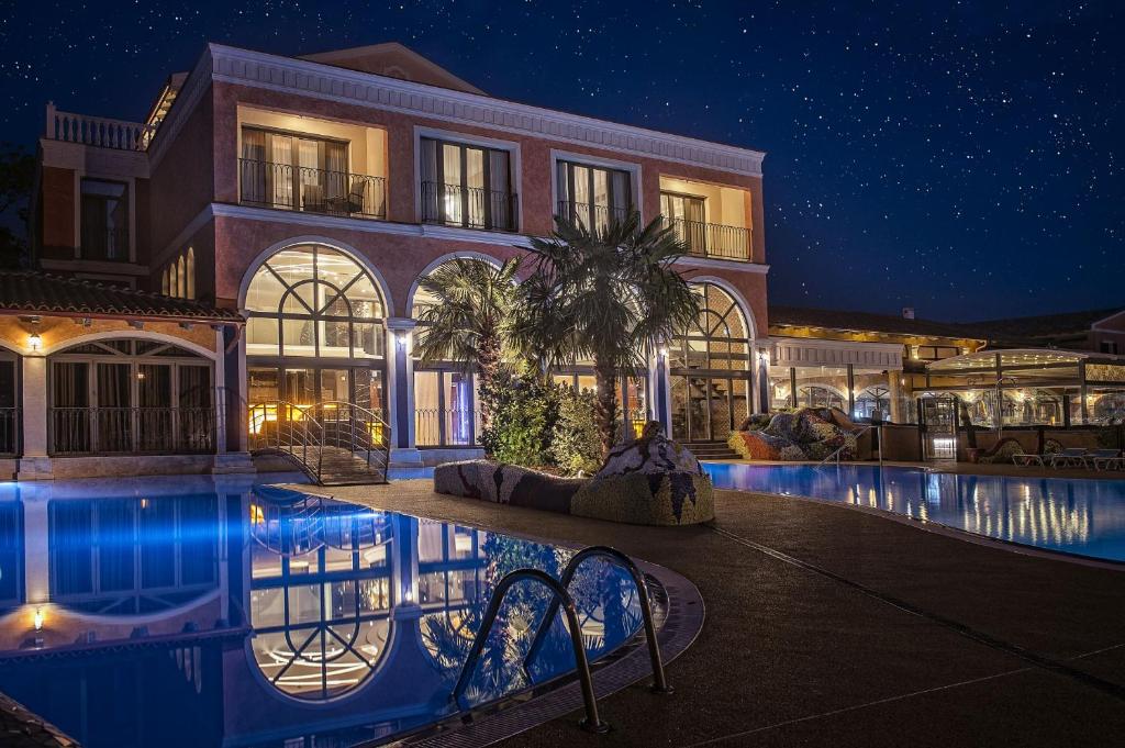 a large building with a swimming pool at night at Villa Plaza Boutique Hotel & Spa in Prešov