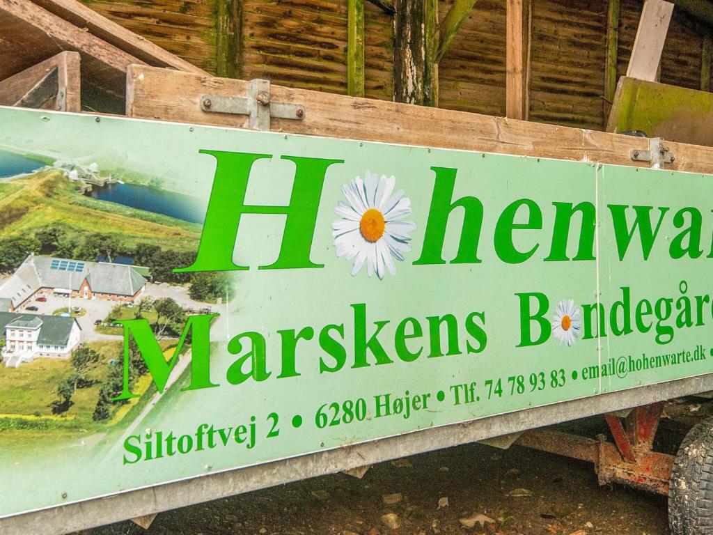 un cartello per una fattoria con un fiore sopra di 4 person holiday home in Højer a Højer
