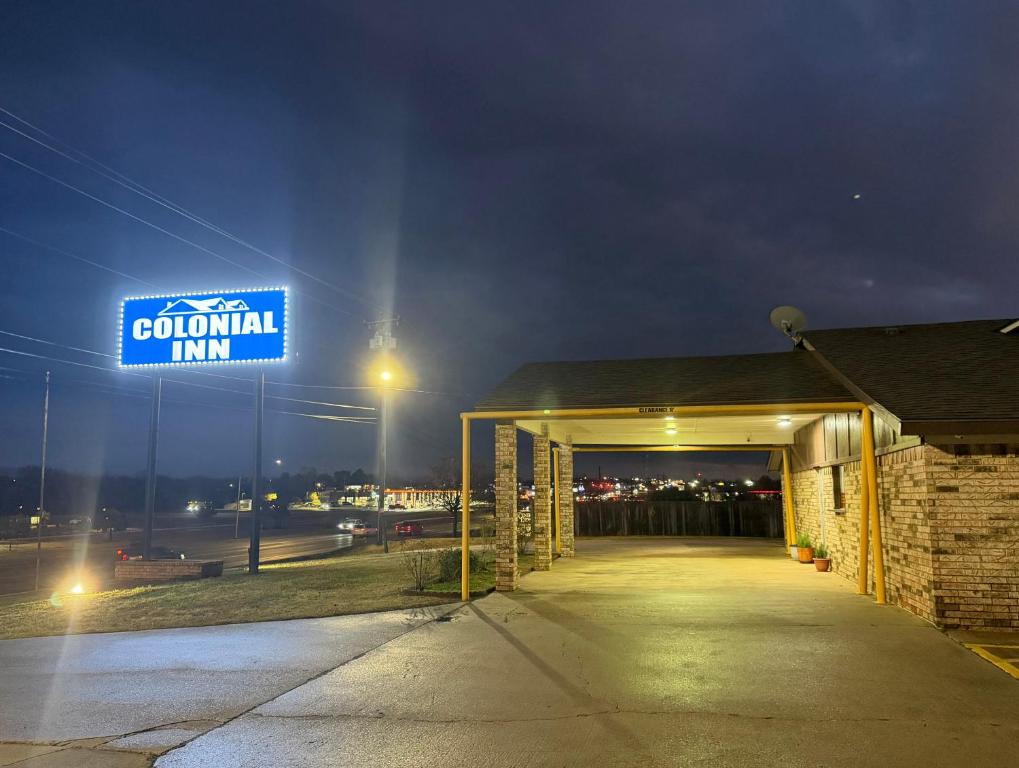 a building with a sign that reads colonial inn at night at Colonial Inn in Shawnee