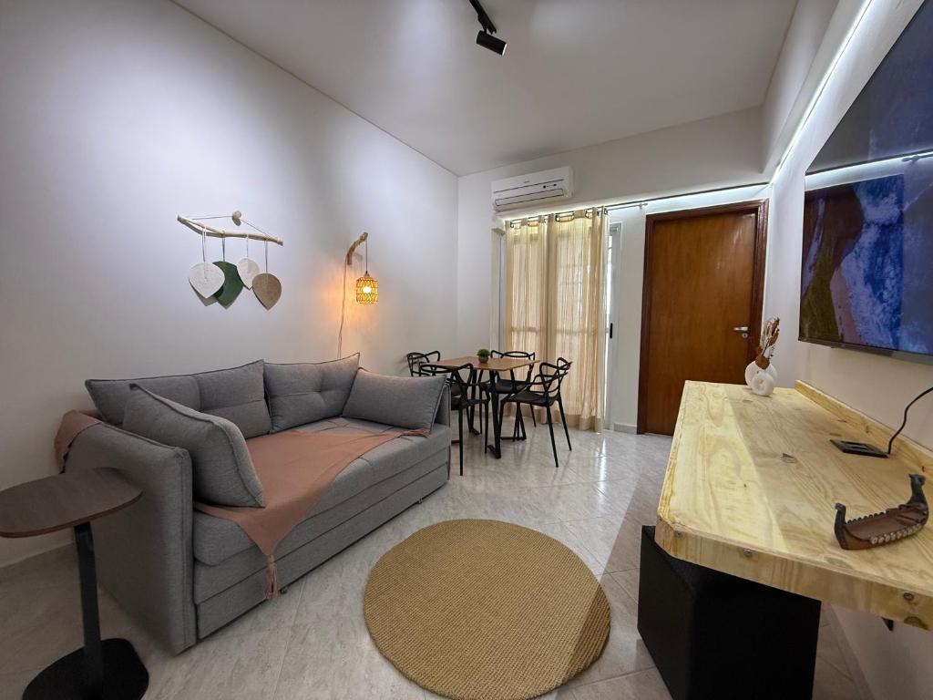 ein Wohnzimmer mit Sofa und Tisch in der Unterkunft Apartamento no Centro de Sorocaba com vaga de garagem in Sorocaba