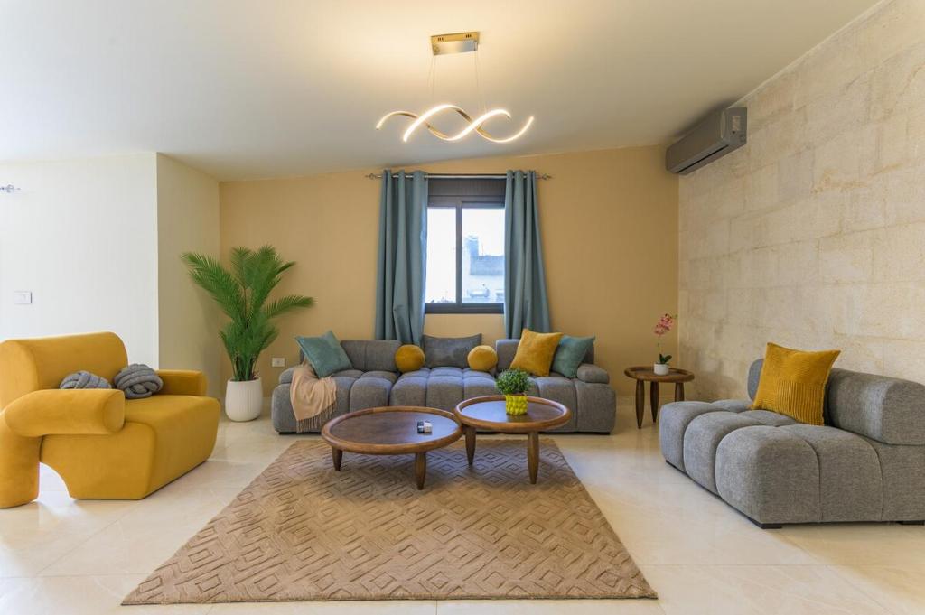 a living room with two couches and a table at Serenada 2BR Apartment In Batroun in Batroûn