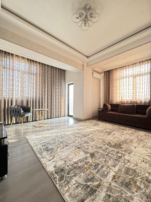 a living room with a couch and a rug at Уютный Апартамент Новостройка 舒适公寓 in Tashkent
