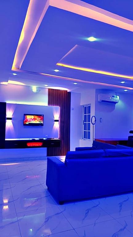 a living room with couches and a flat screen tv at Annabelle & Annabelle Apartment in Abeokuta