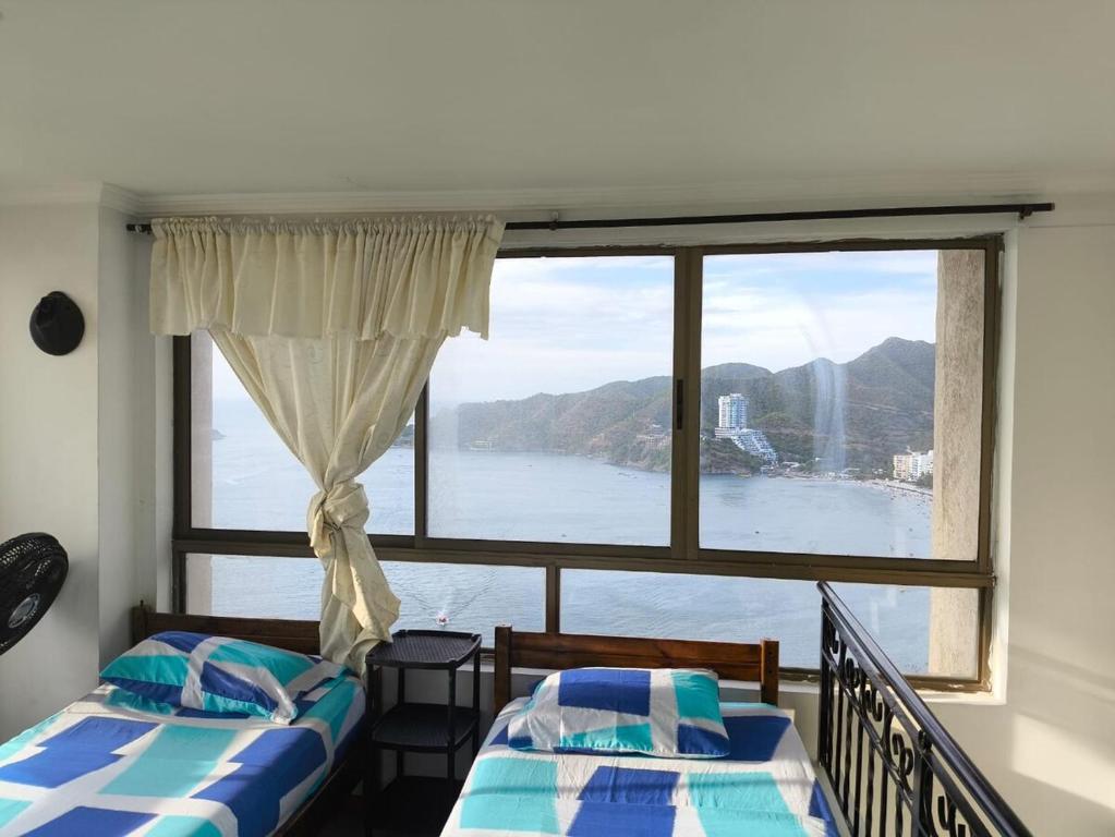 due letti in una stanza con una grande finestra di El Peñon-Rodadero-Sunset-Cheap Building a Rodadero