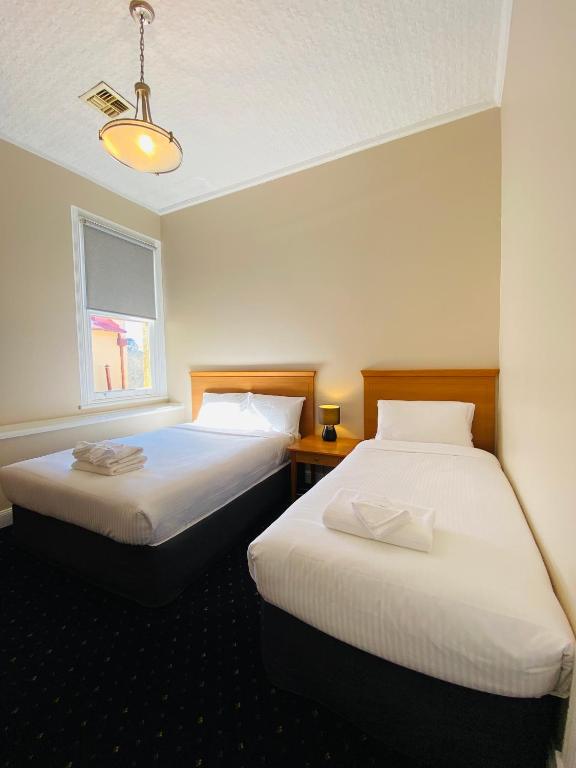 two beds sitting next to each other in a room at Gardners Inn Hotel in Blackheath