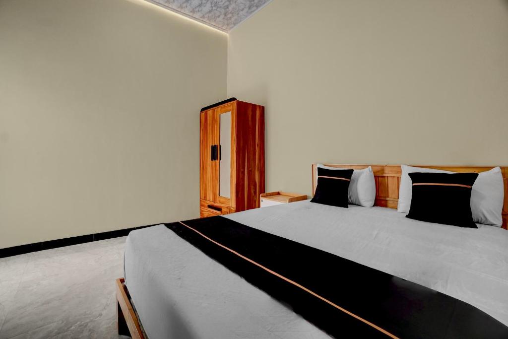 MojokertoにあるOYO 94924 Cidu Homestay Syariahの黒と白の枕が付いた大きなベッドのある寝室
