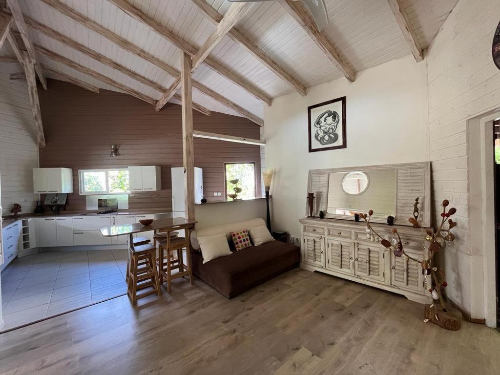 a kitchen and living room with a couch and a table at Villa F3, Eden Krys, a cocoon of tranquility in La Trinité