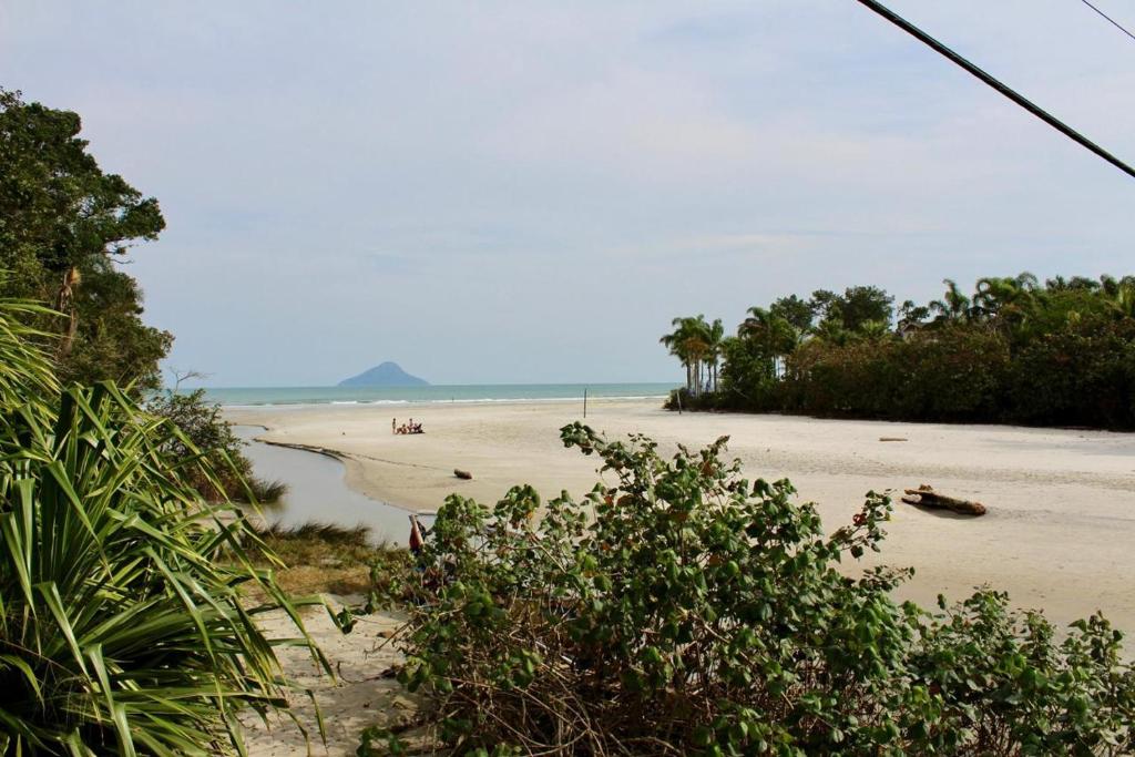 a beach with trees and the ocean in the background at Casa em Juquehy 200m da praia in São Sebastião