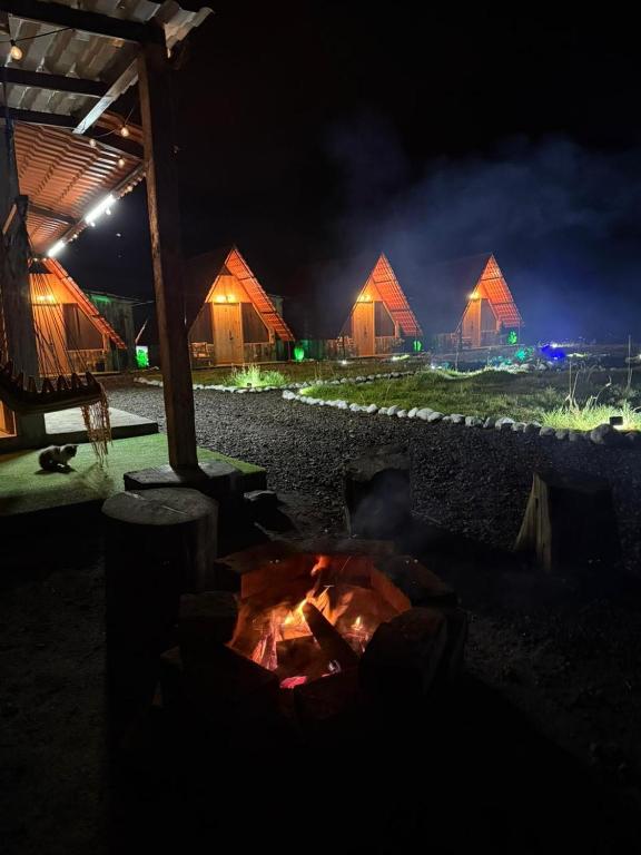 a fire pit in front of some tents at night at Sigchos Lodge in Sigchos
