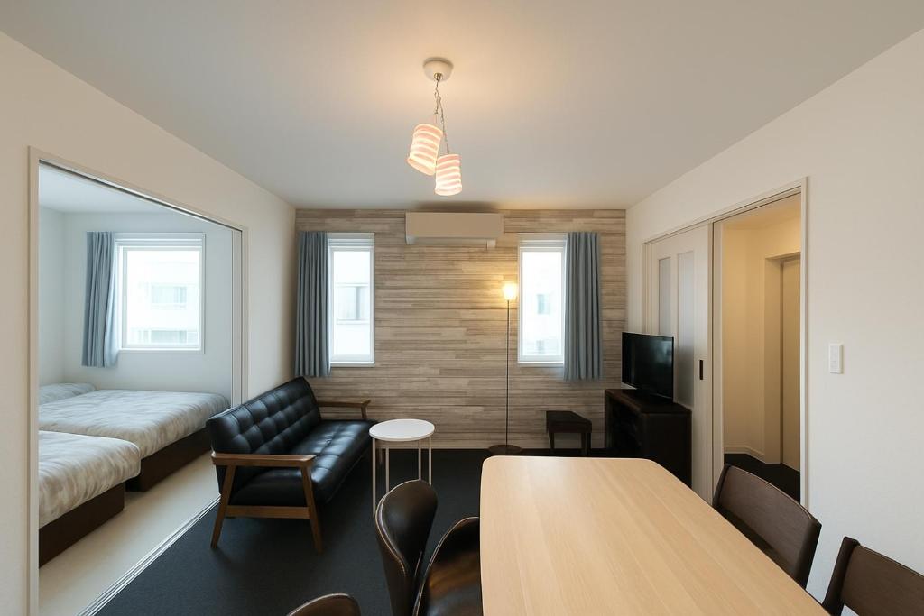 um quarto com uma cama, uma mesa e um sofá em 優富良野 em Furano