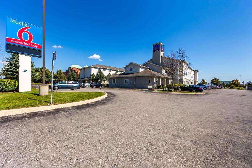 a parking lot with a sign in front of a building at Studio 6 Toronto - Mississauga with Kitchenettes in Mississauga
