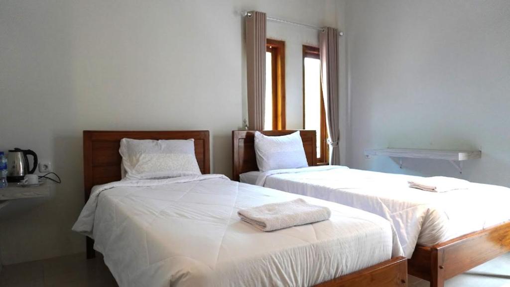two beds sitting next to each other in a room at Savira Golo Koe Labuan Bajo in Komodo Labuan Bajo Airport