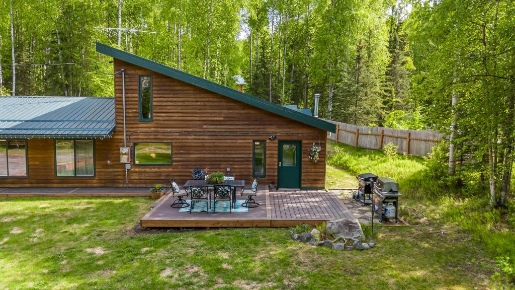 una baita di tronchi con terrazza nel cortile di Cozy Lakefront Retreat a Wasilla