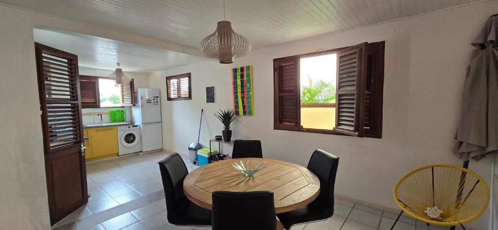 een eetkamer met een houten tafel en stoelen bij Villa JOSAMY Charmante Villa avec Piscine à Deux Pas de la Mer in Sainte-Luce