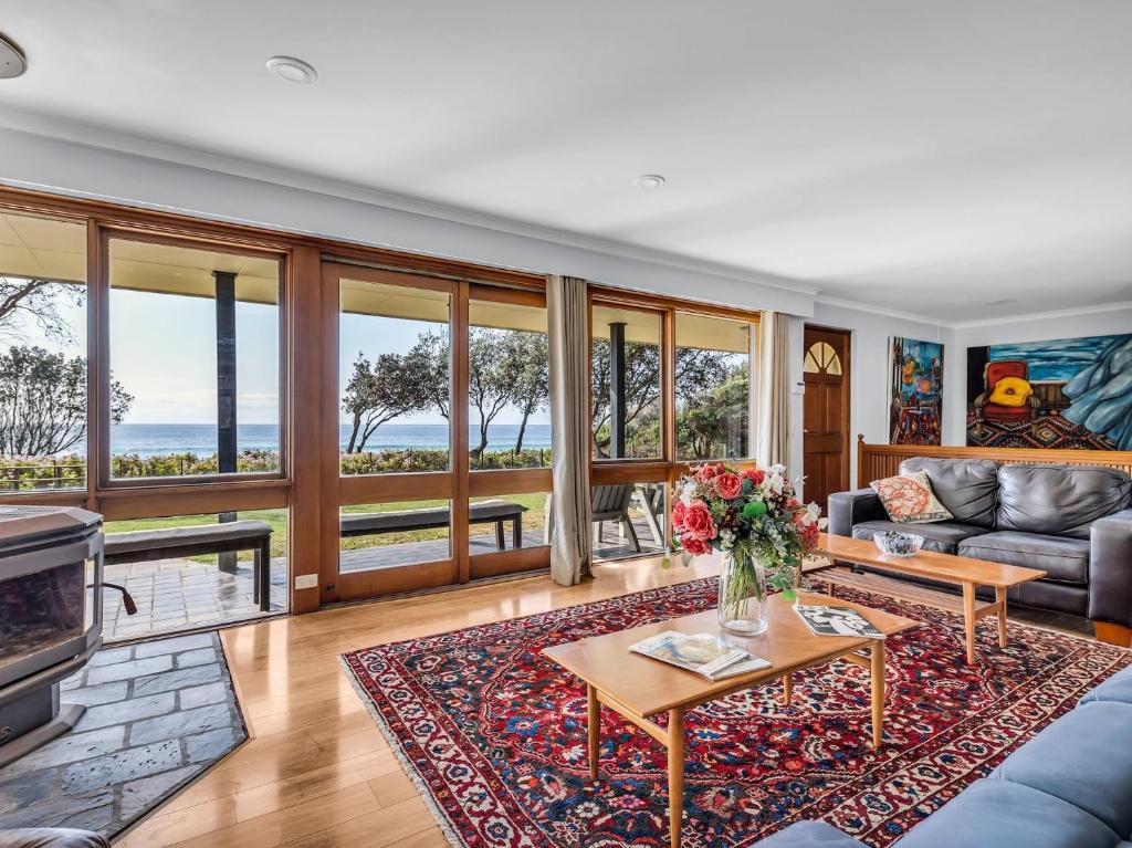 a living room with a couch and a table at Art House - 4 Bedroom in Barragga Bay