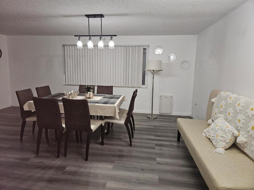 新里奇港Newly Renovated Vacation home with Spacious Pool的一间带桌椅和沙发的用餐室