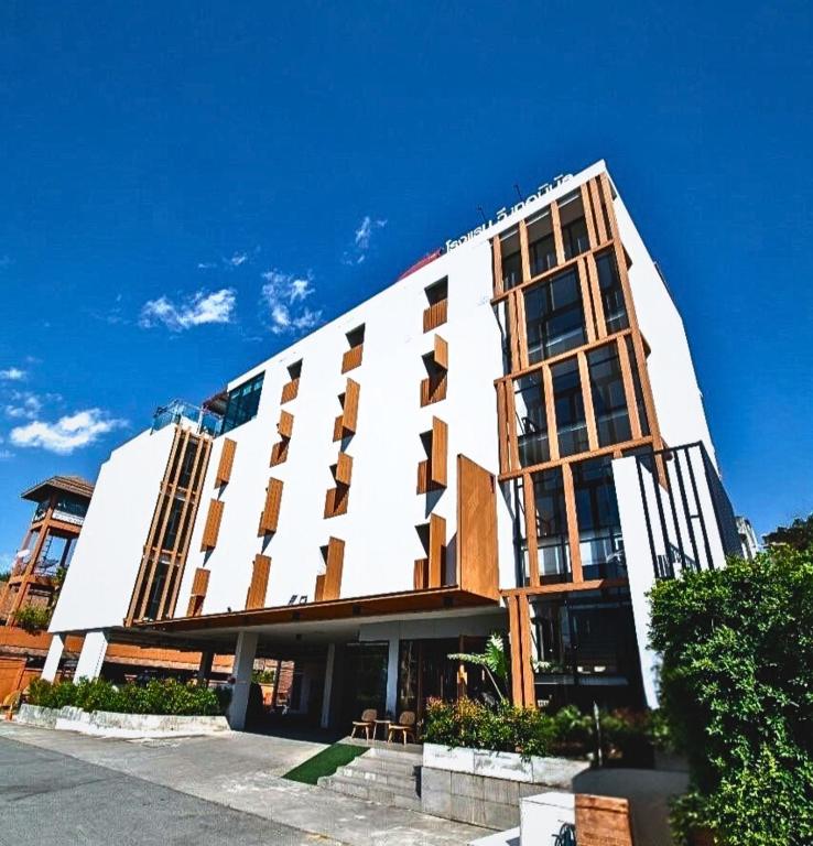 a large white building with windows on the side of it at WE Terminal Hotel in Chiang Mai