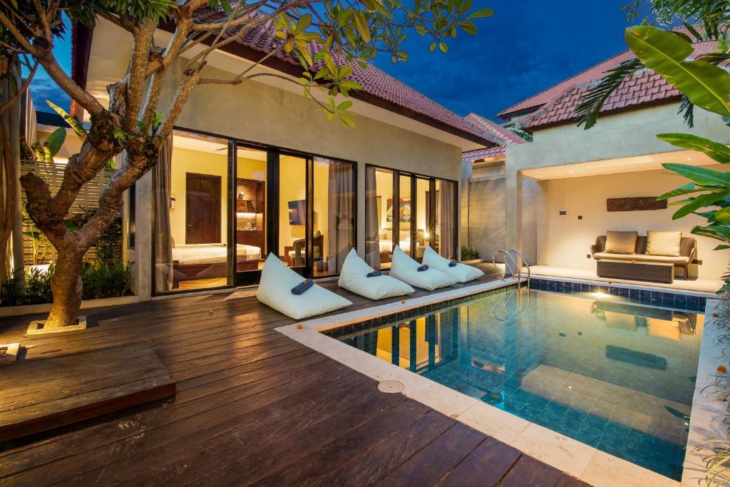 een villa met een zwembad en een huis bij Le Cielo Resort Canggu Batu Bolong by Maviba in Canggu