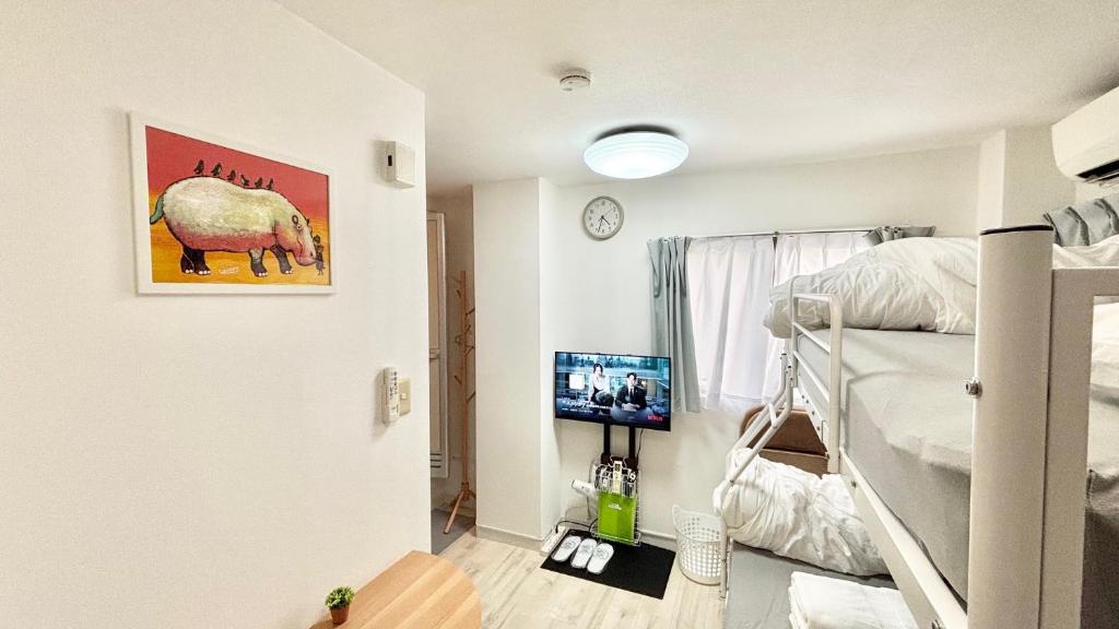 ein Schlafzimmer mit einem Etagenbett und einem TV in der Unterkunft Good One Awaji Accessia 301 in Osaka