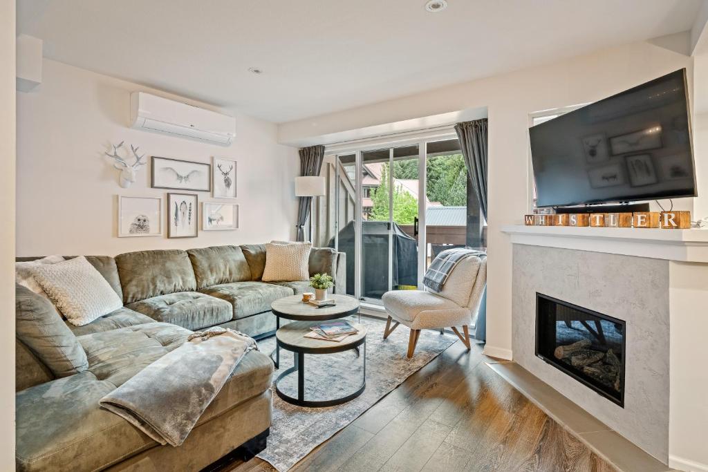 a living room with a couch and a fireplace at Private Hot Tub | Pool | AC | Free Parking in Whistler