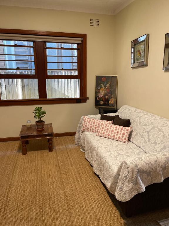 a living room with a couch and a table at SUNNY STUDY ROOM ATTACHED IN SPACIOUS PRIATE ROOM Eastwood in Sydney