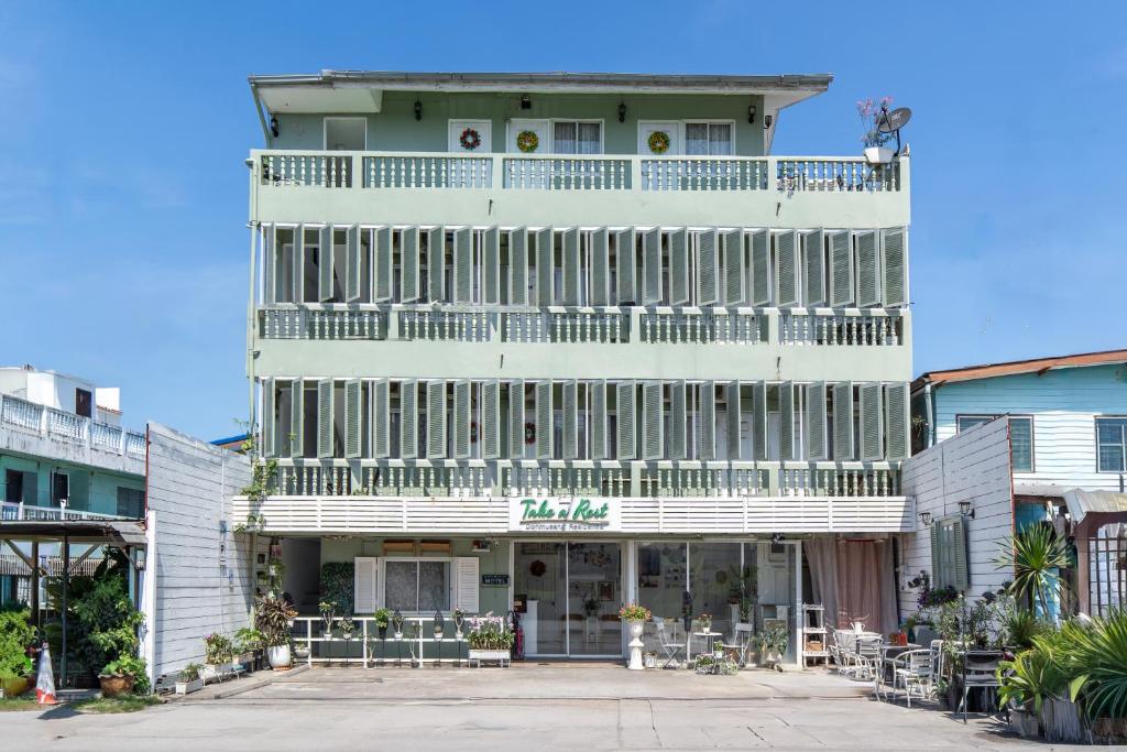 a white building with a balcony on top of it at Take a Rest Donmueang in Ban Don Muang