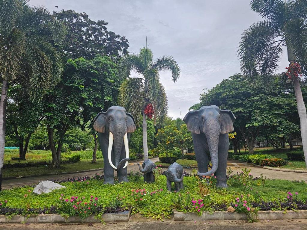 a statue of two adult elephants and two baby elephants at Kaengkrachan Diamond Green Resort in Ban Song Phi Nong