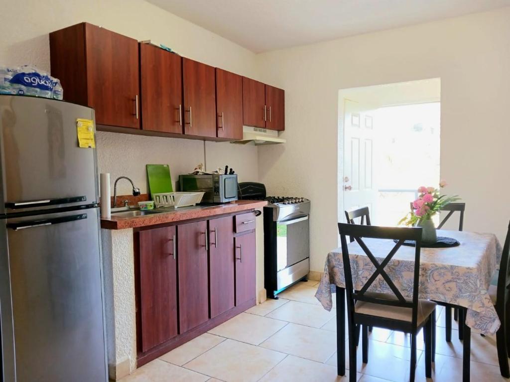 a kitchen with a table and a stainless steel refrigerator at Serenity Luxury Villa in Sandy Bay