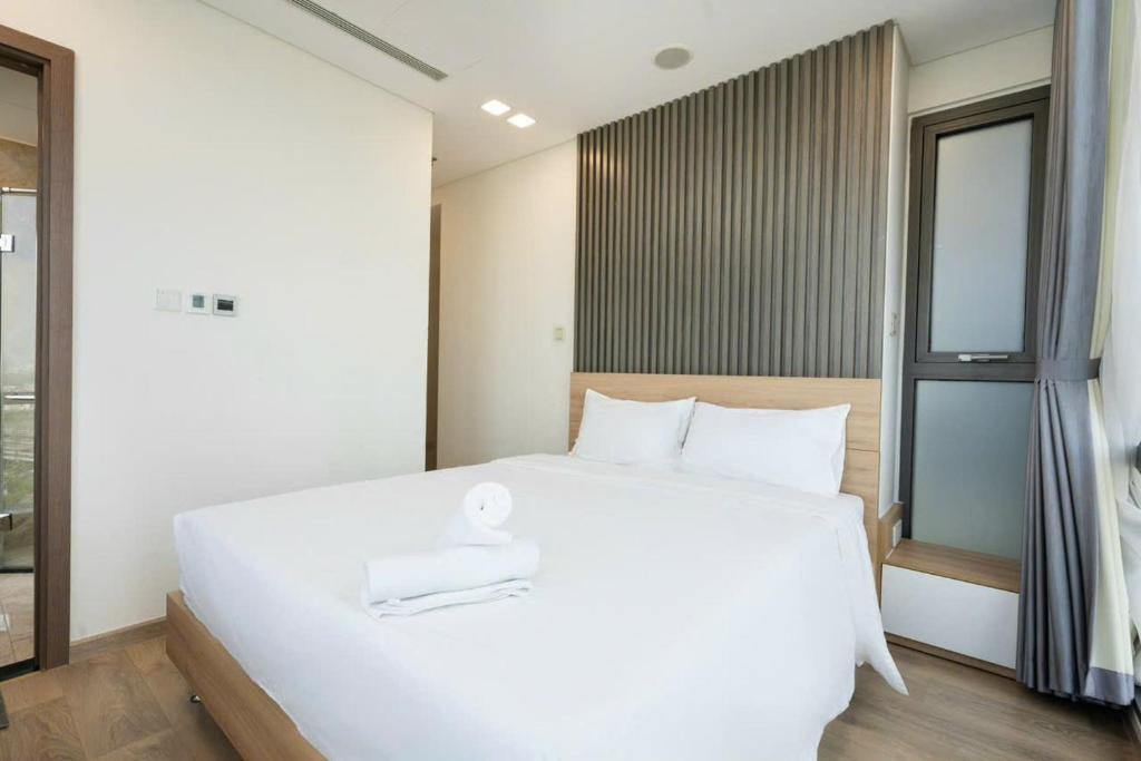 a large white bed in a room with a window at SG lusxury city in Ho Chi Minh City
