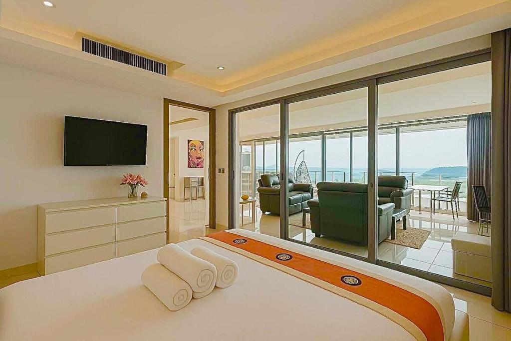 ein Schlafzimmer mit Bett und Fernseher sowie ein Wohnzimmer in der Unterkunft The View Kata Karon in Kata Beach