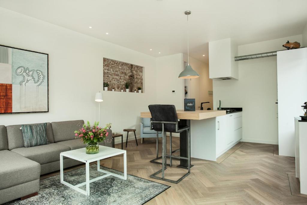 デン・ハーグにあるStayci Serviced Apartments Dennewegのリビングルーム、キッチン(ソファ、テーブル付)