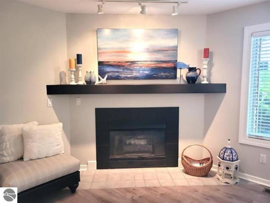 a living room with a fireplace with a painting at A Ga Ming Escape Best Torch Lake Views Golf 755 in Creswell